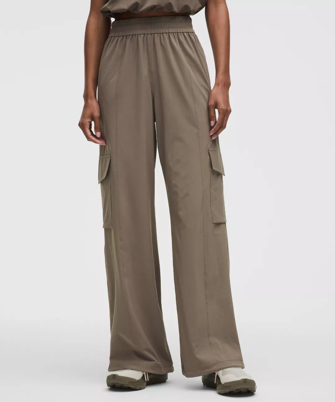 Person wearing brown cargo pants on a white background
