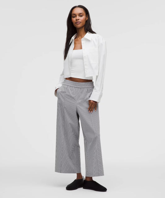 Woman wearing a white blouse and gray pants on a white background