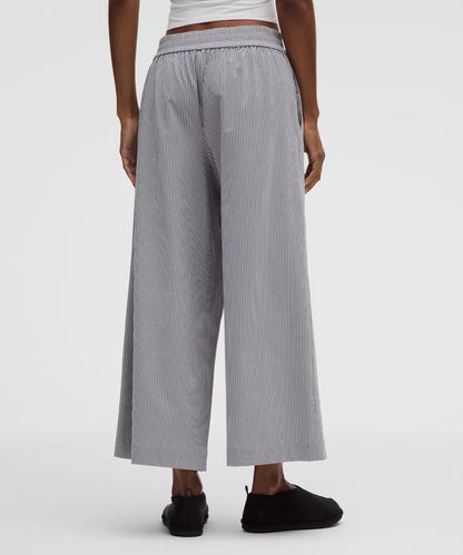 Person wearing gray striped wide-leg pants on a white background