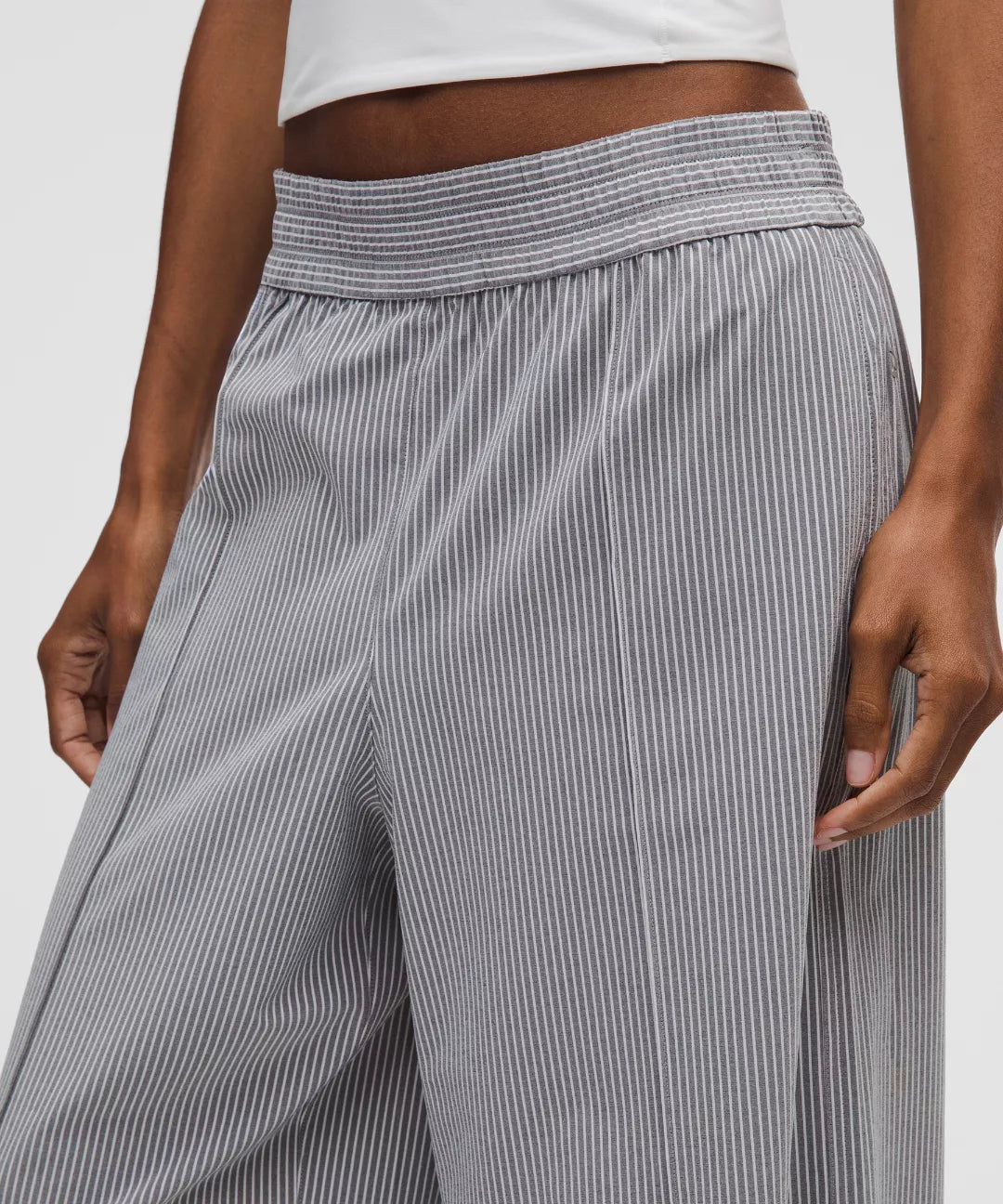Gray striped pants worn by a person on a white background