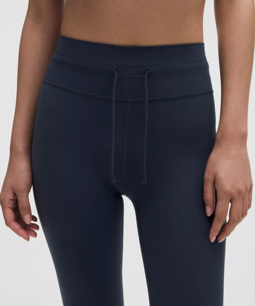 Navy blue leggings worn by a person on a white background