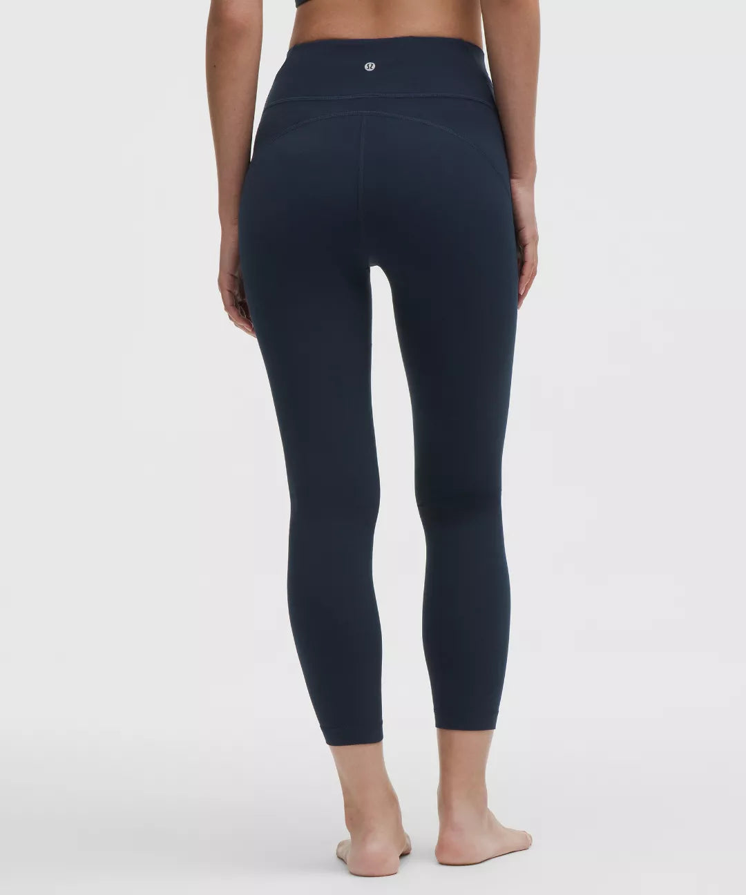 Navy blue leggings worn by a person on a white background