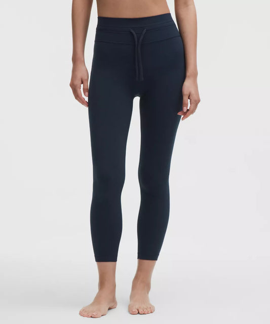 Person wearing navy blue leggings on a white background