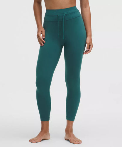 Teal leggings worn by a person on a white background