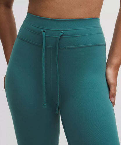 Teal leggings with a drawstring waistband on a white background