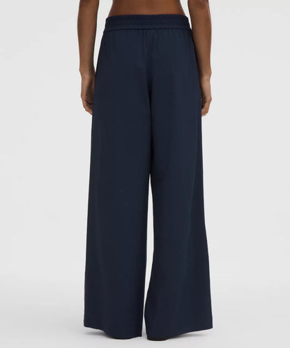 Navy wide-leg pants worn by a person on a white background