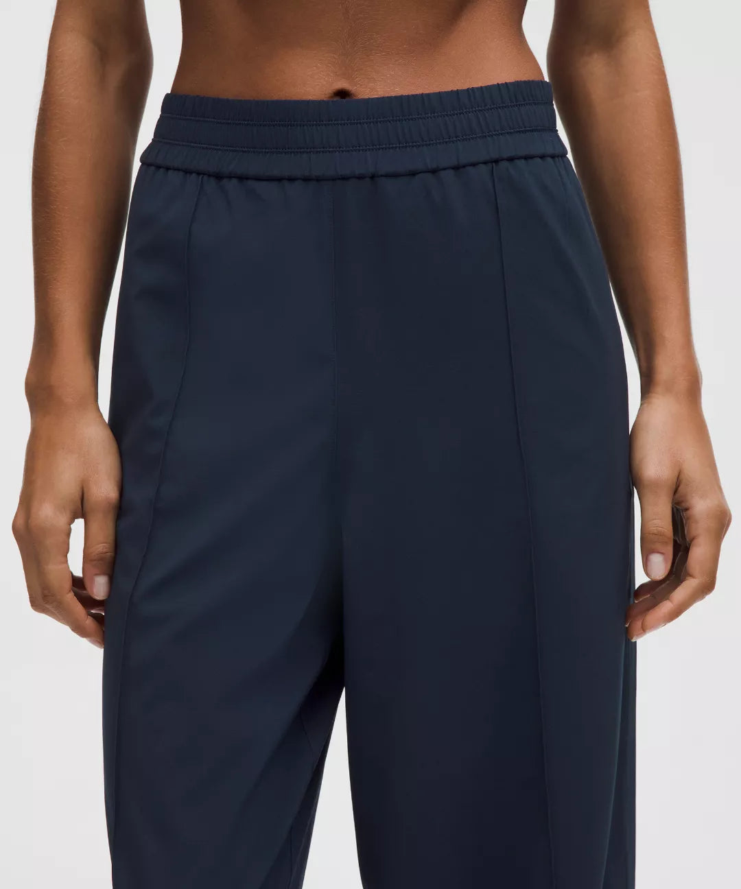 Navy blue pants worn by a person on a light gray background