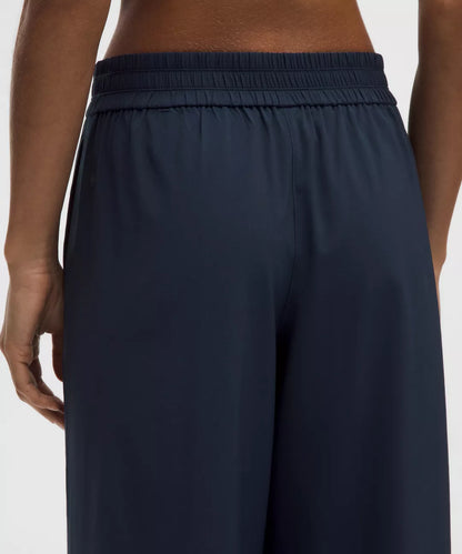Navy blue pants worn by a person on a white background