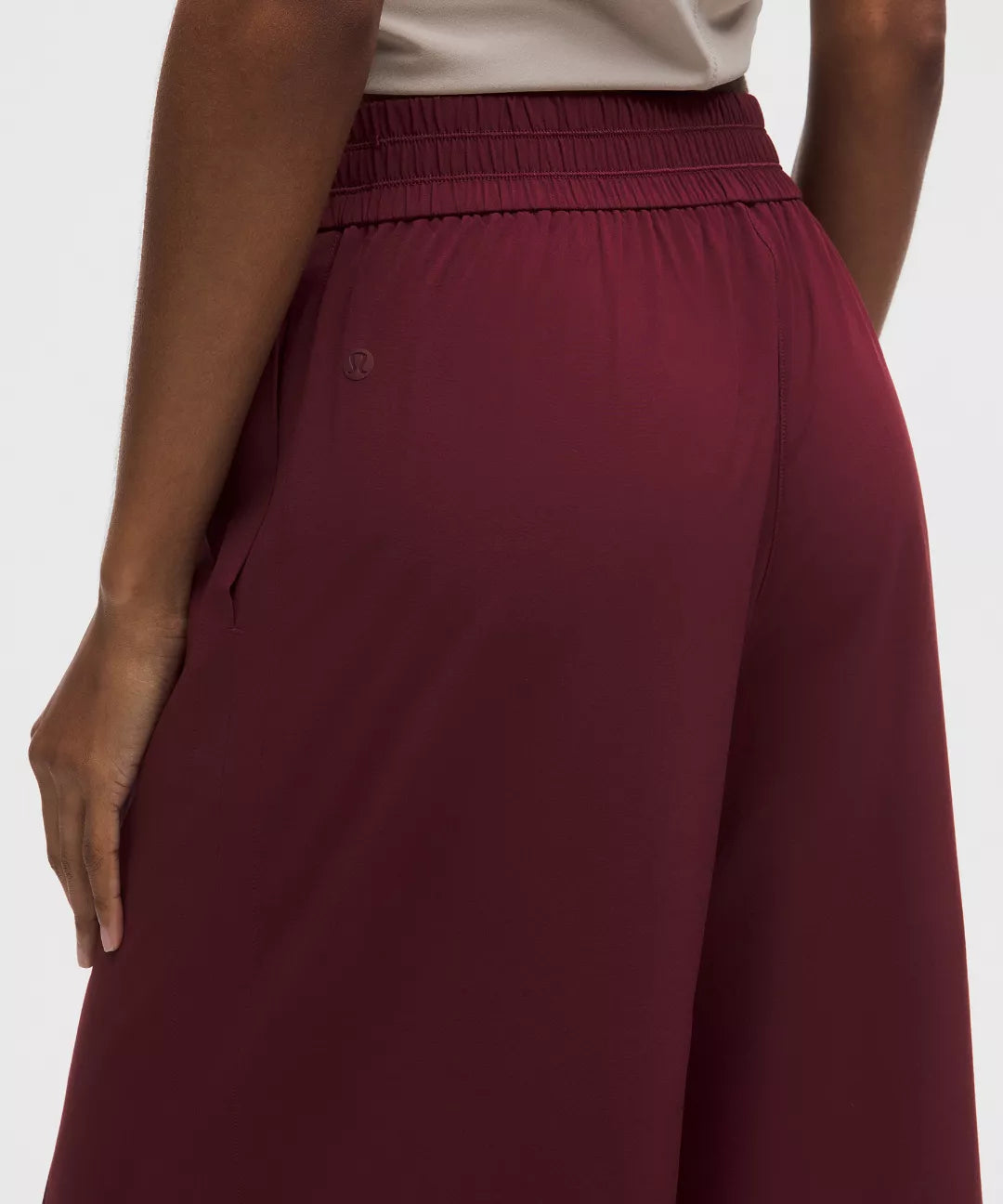 Maroon pants worn by a person on a white background