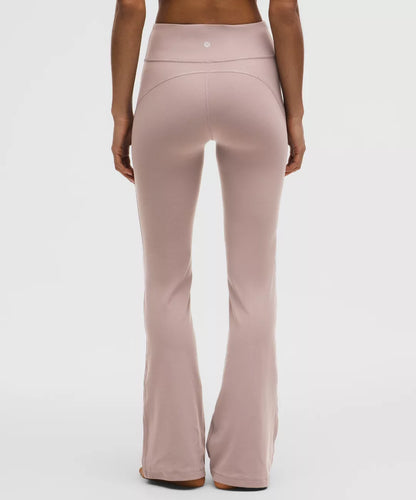 Person wearing a pair of pink flared pants on a white background