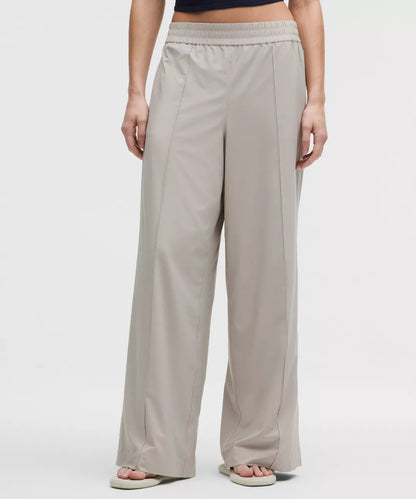 Beige wide-leg pants worn by a person on a white background