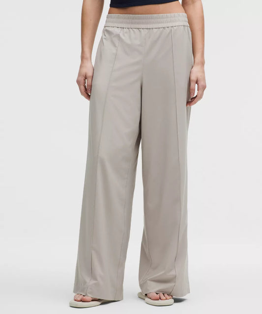 Beige wide-leg pants worn by a person on a white background