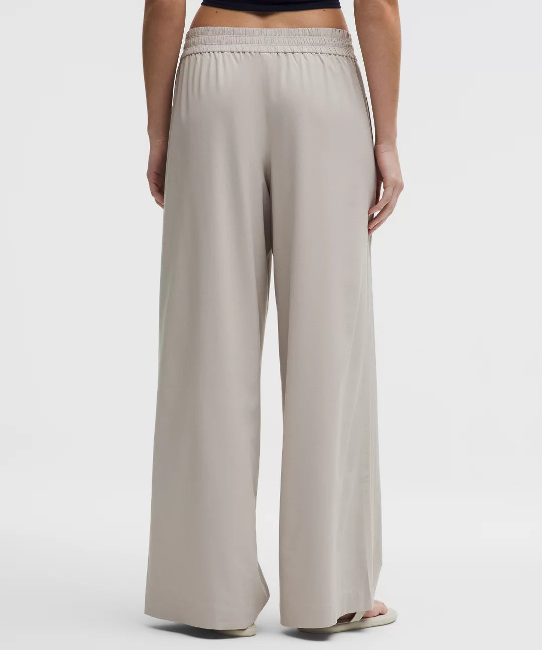 Beige wide-leg pants worn by a person on a white background