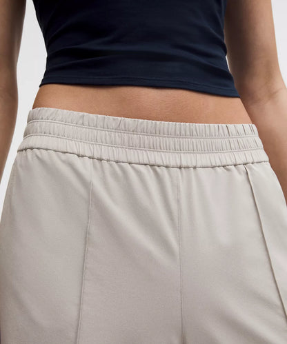 Person wearing a navy top and beige pants on a light background