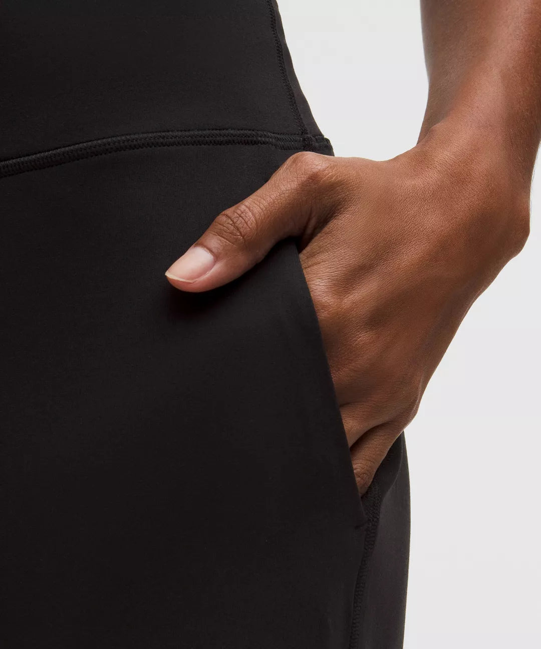 Hand inserting into a black pocket on a plain background