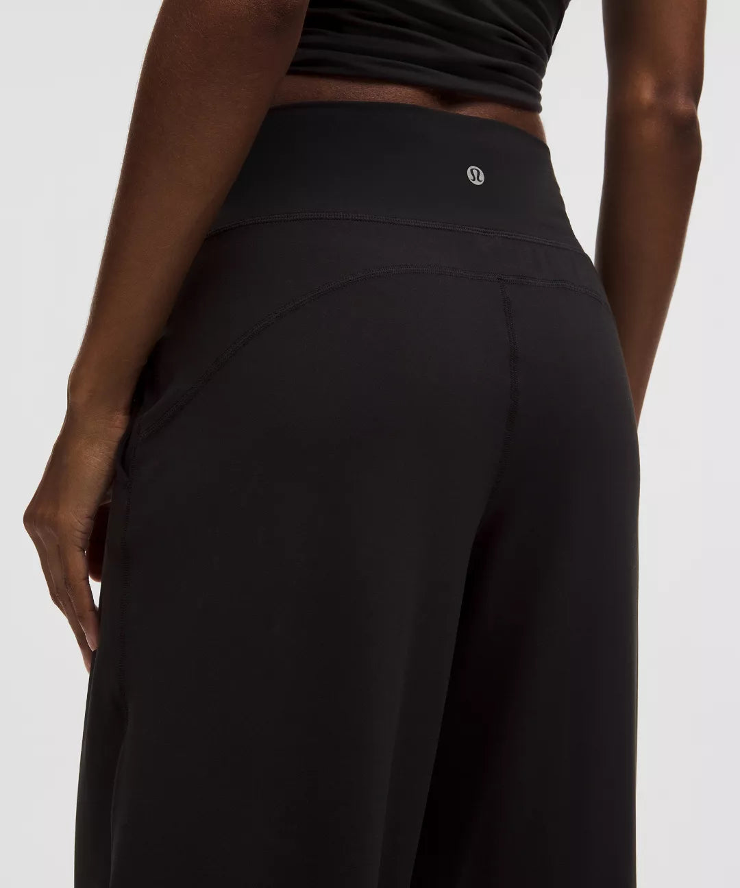 Black pants worn by a person on a white background