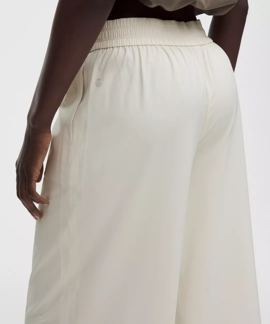White pants worn by a person on a white background
