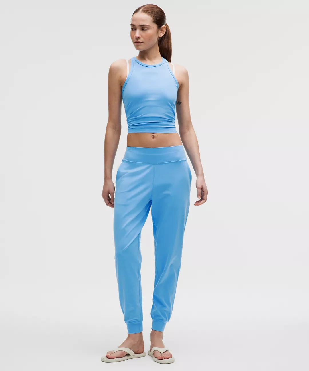 Woman wearing a blue athletic outfit on a white background
