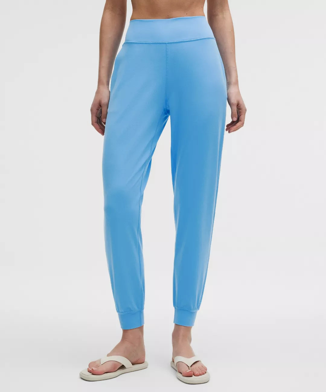 Person wearing light blue leggings on a white background