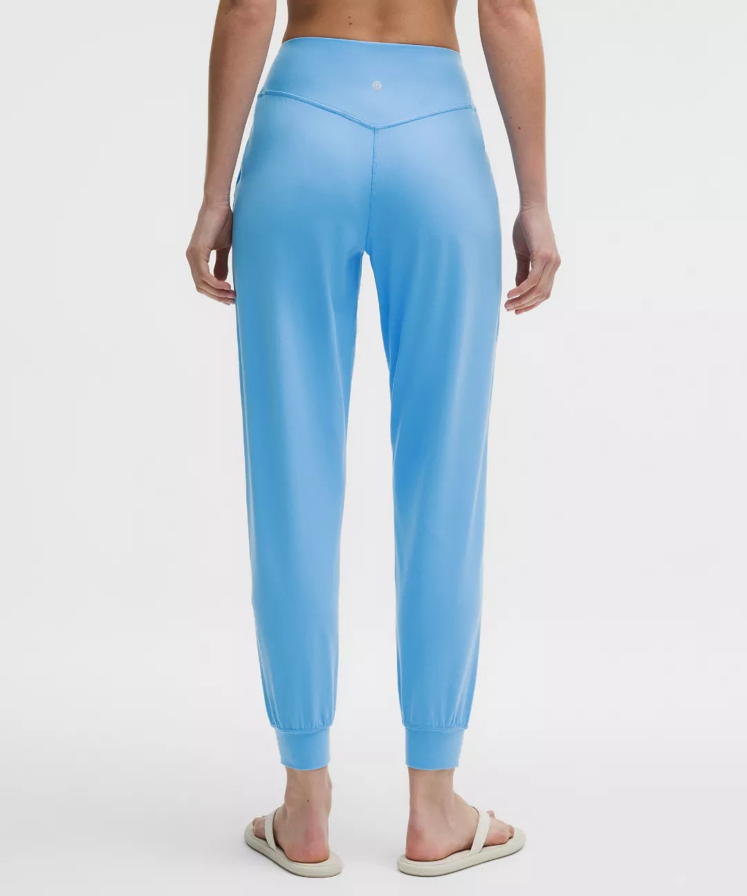 Light blue jogger pants worn by a person on a white background