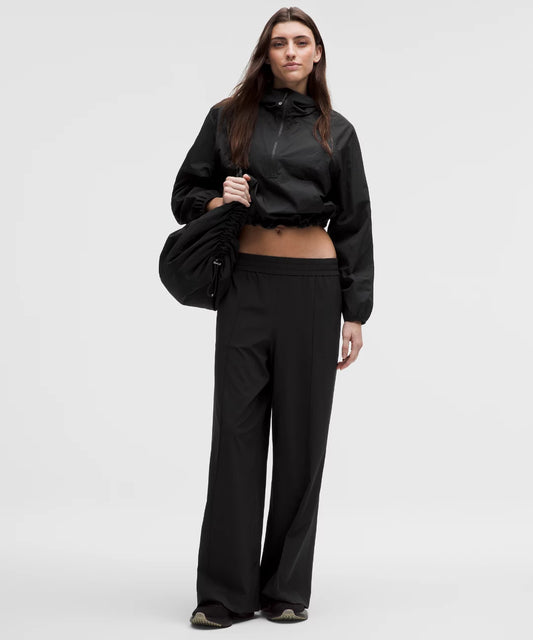 Person wearing a black outfit with a jacket and pants on a white background