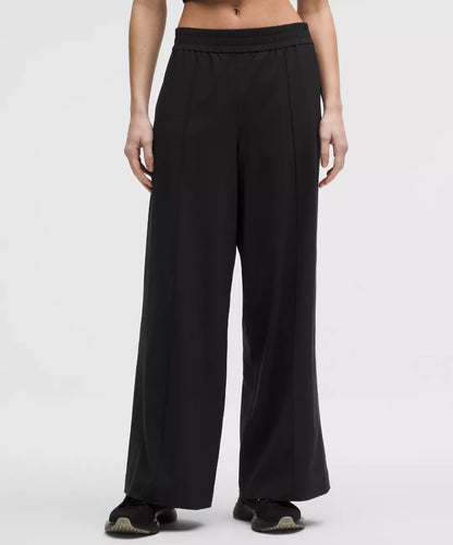 Black wide-leg pants worn by a person on a white background