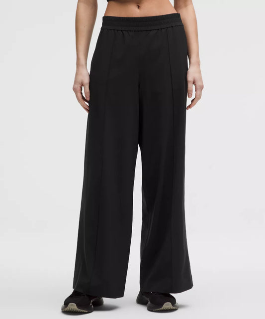 Black wide-leg pants worn by a person on a white background