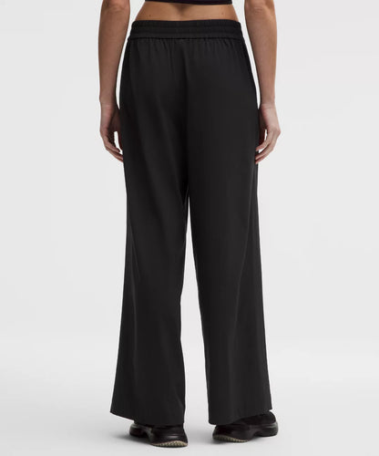 Person wearing black wide-leg pants on a white background