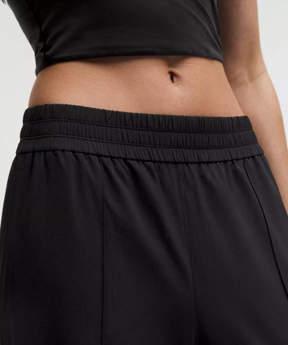 Person wearing black pants and a black top on a light gray background