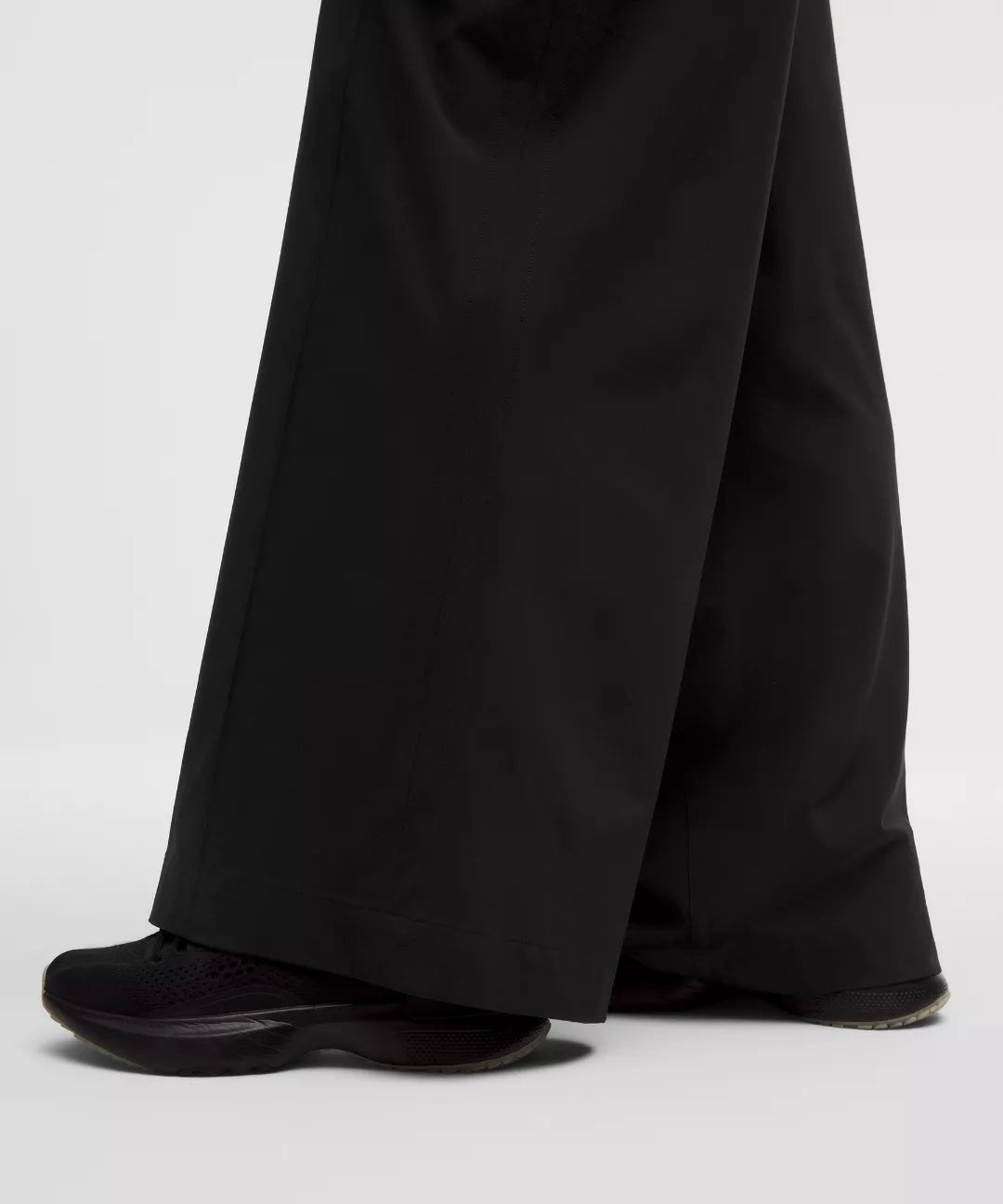Black wide-leg pants and black shoes on a white background