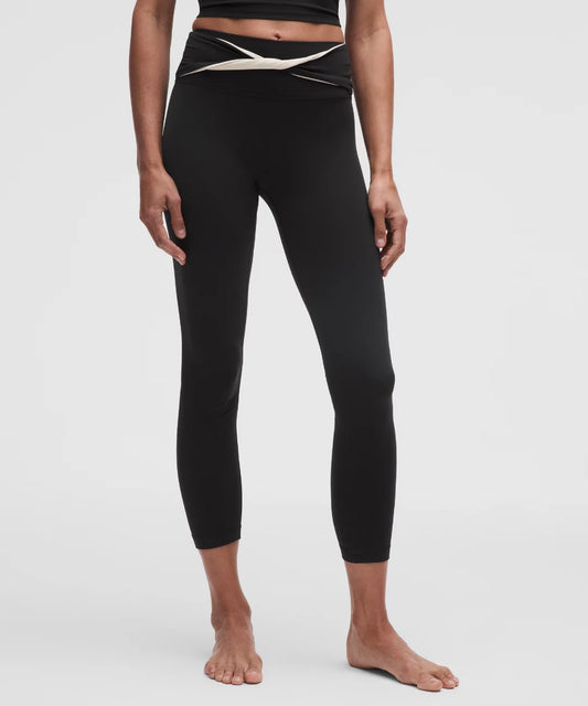 Person wearing black leggings with a white waistband on a white background