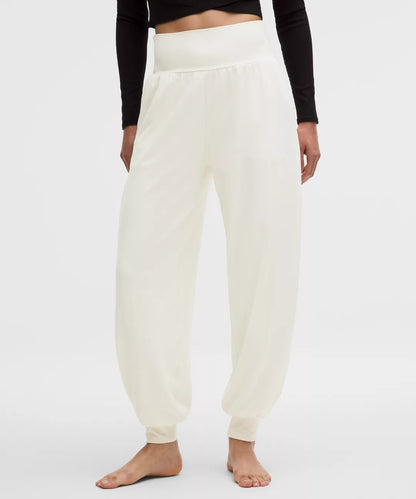 Person wearing white sweatpants on a plain background