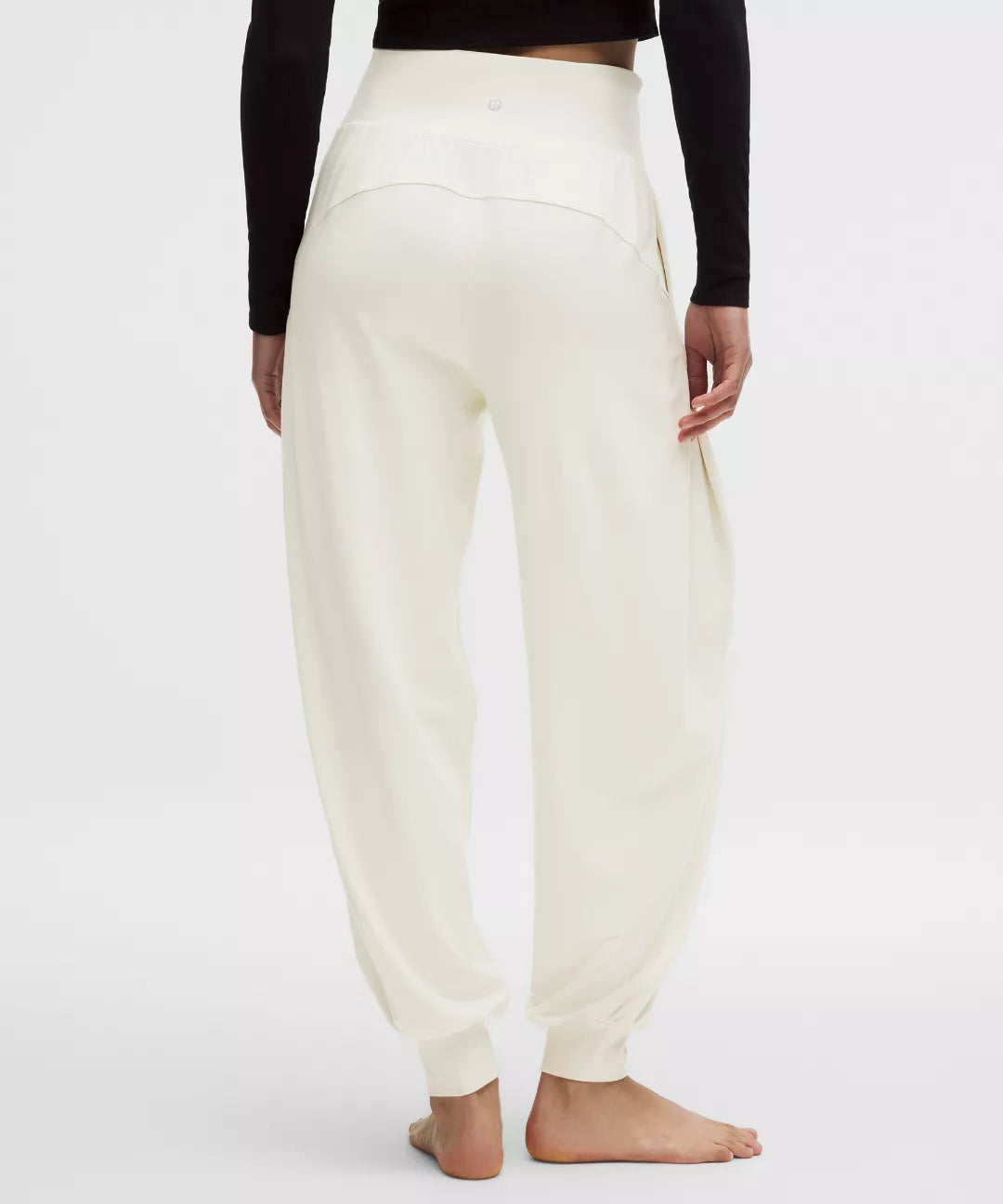White jogger pants worn by a person on a white background