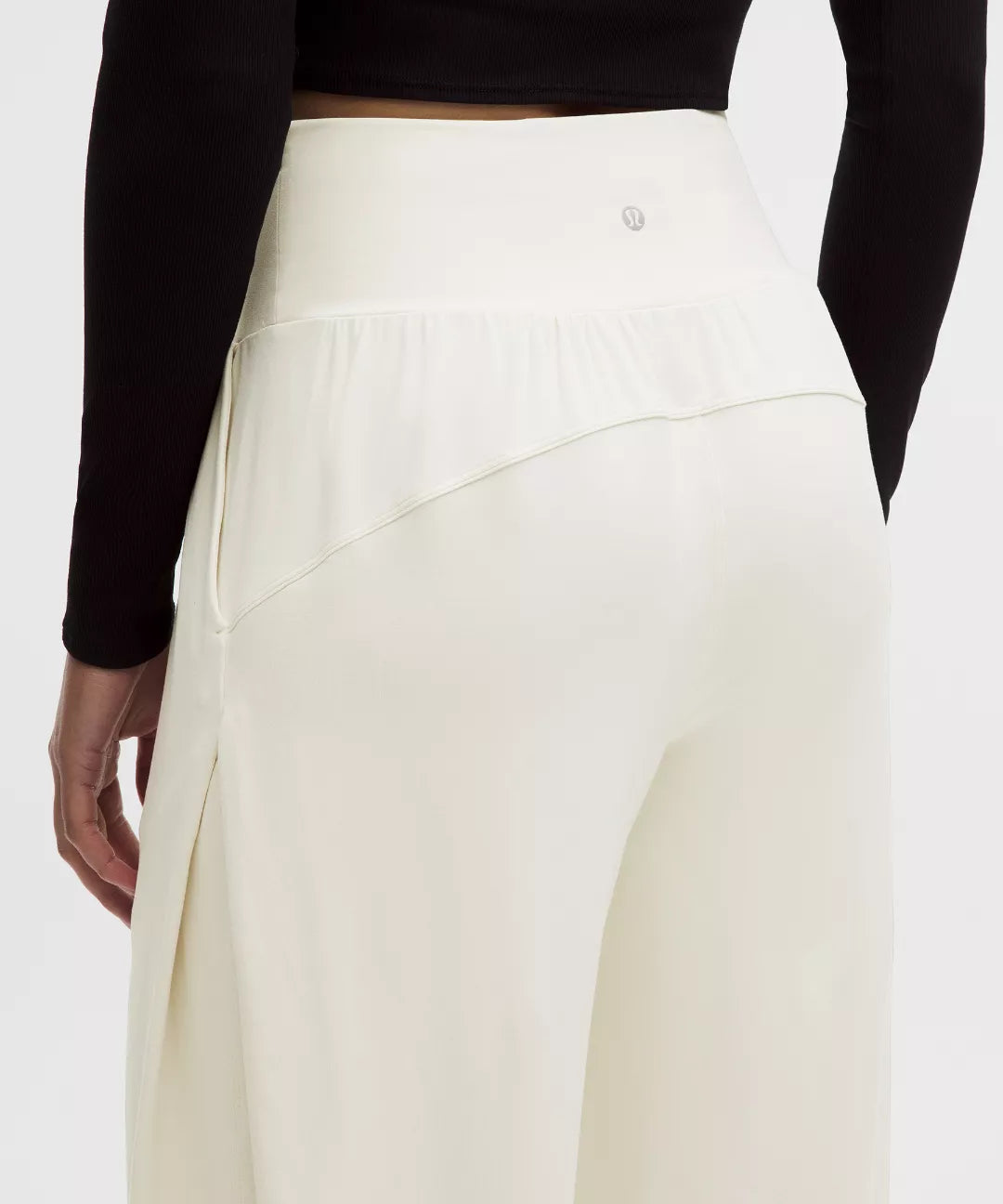 White pants worn by a person with a black top on a white background