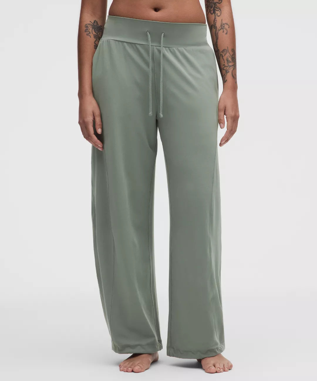 Person wearing green lounge pants on a white background