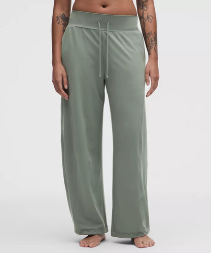 Person wearing green lounge pants on a white background