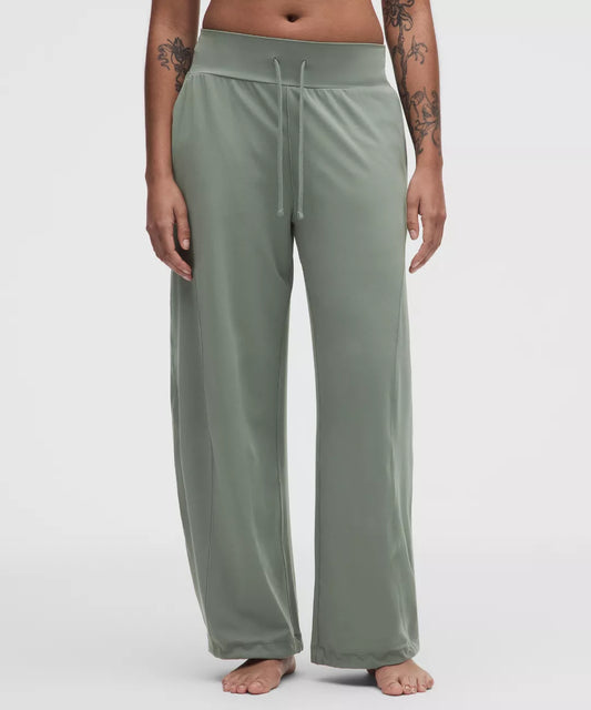 Person wearing green lounge pants on a white background