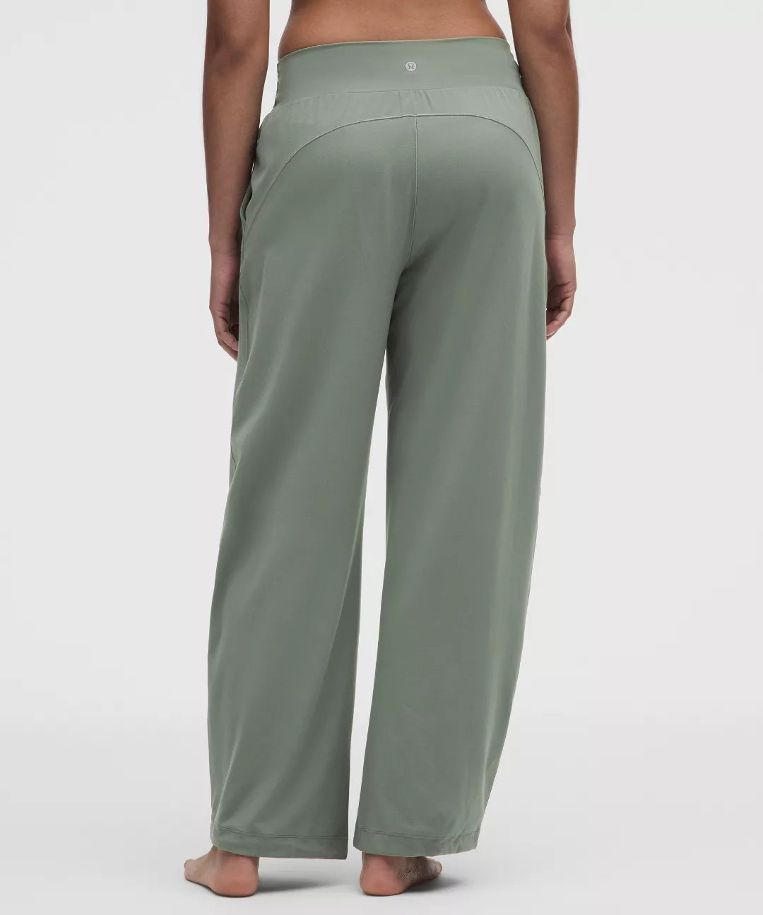 Green wide-leg pants worn by a person on a white background