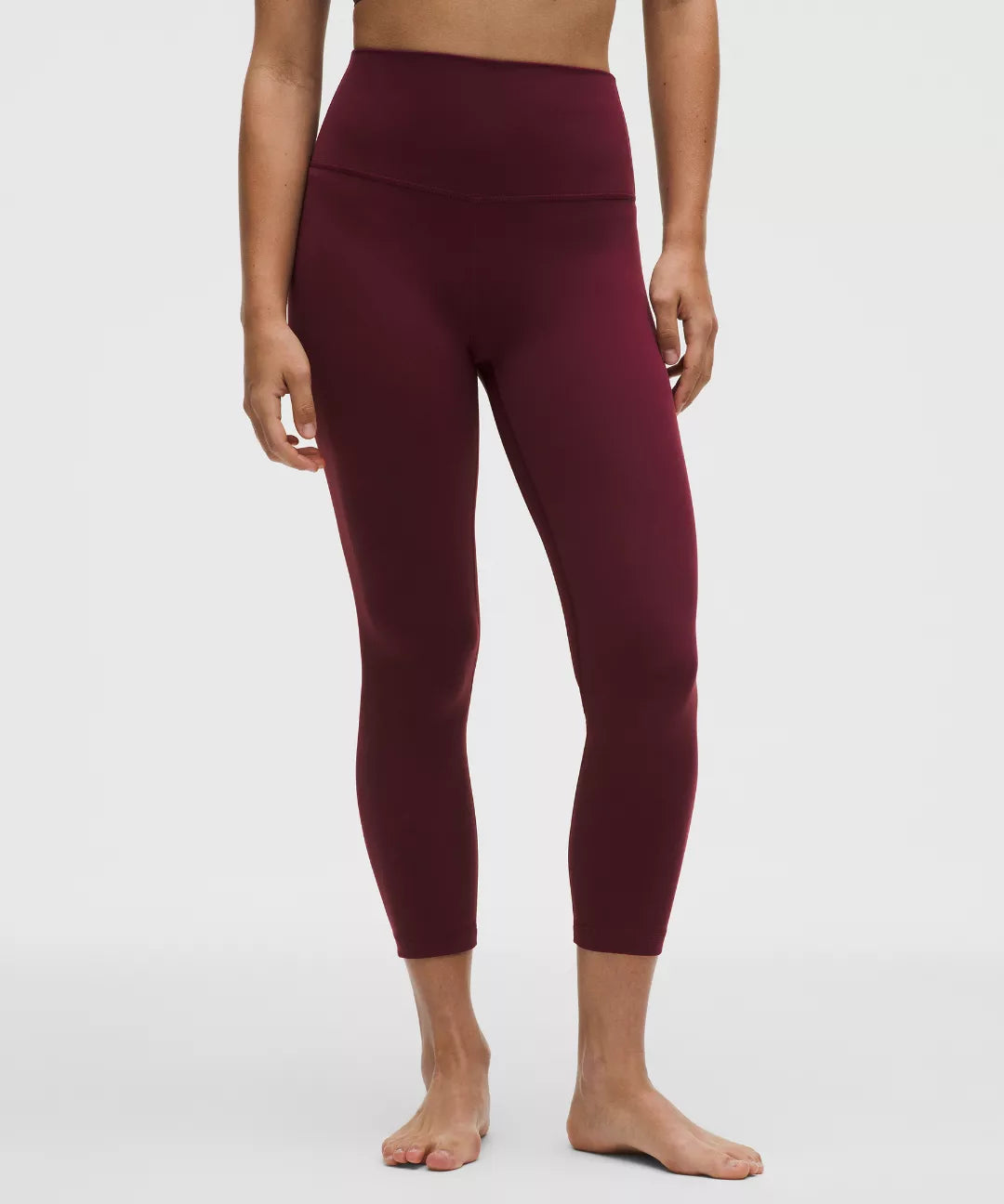Maroon leggings worn by a person on a white background