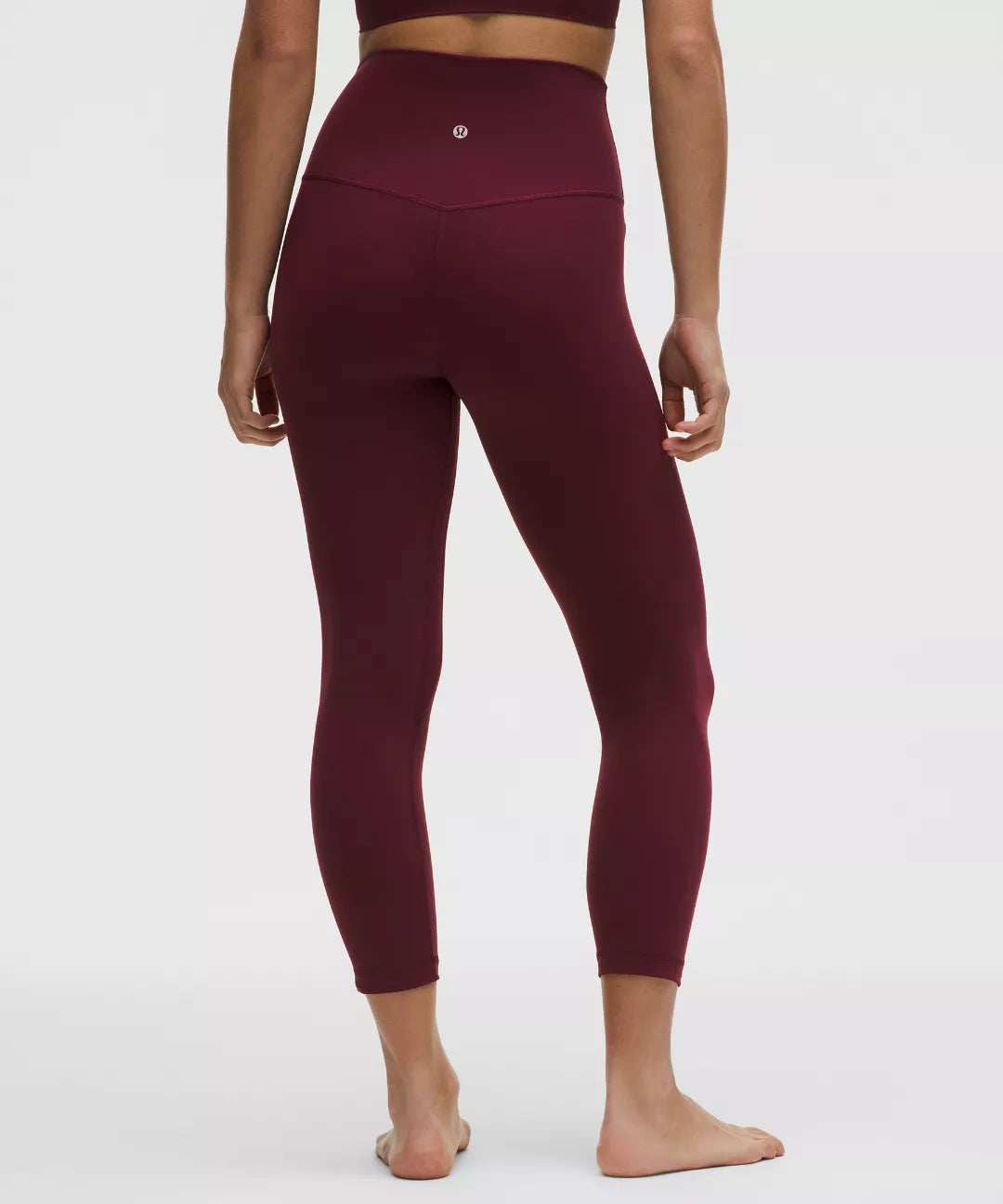 Maroon leggings worn by a person on a white background