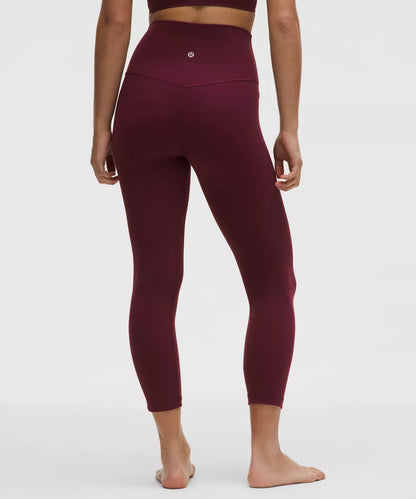 Maroon leggings worn by a person on a white background