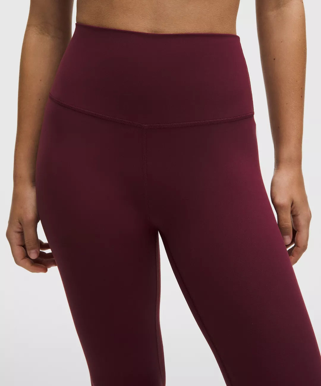 Maroon leggings worn by a person on a light gray background