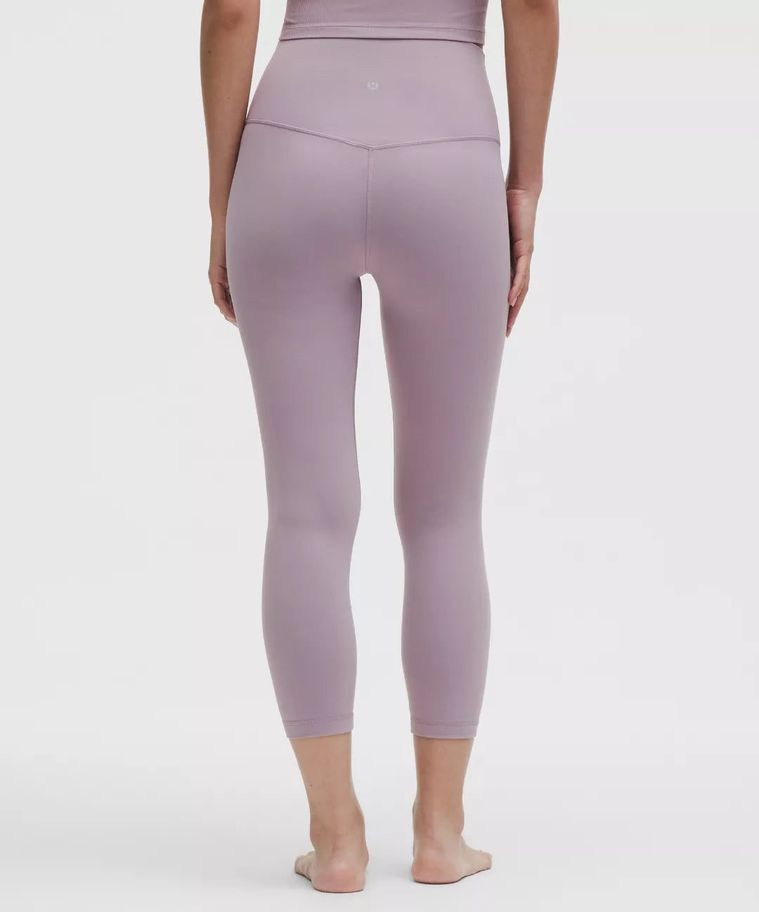 Person wearing a pair of mauve leggings on a white background