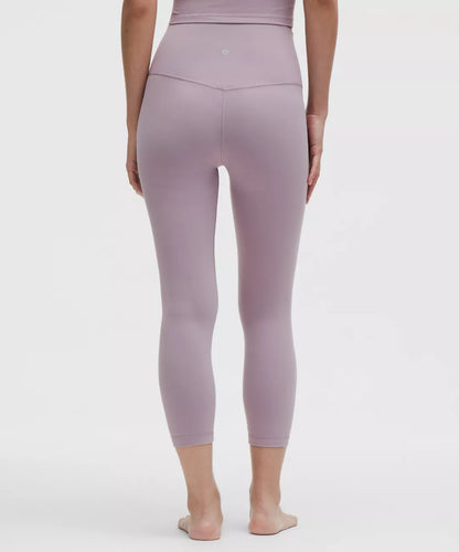 Person wearing a pair of mauve leggings on a white background