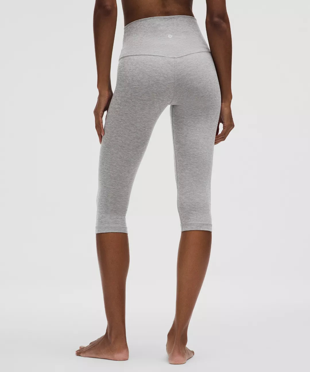 Person wearing gray leggings on a white background