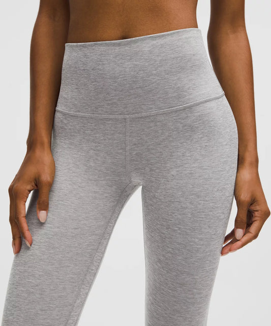 Gray leggings worn by a person on a white background