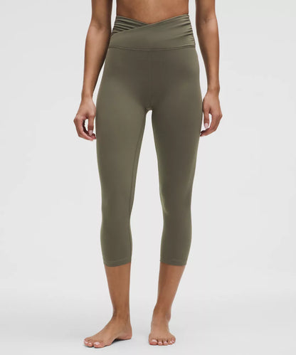 Person wearing olive green leggings on a white background
