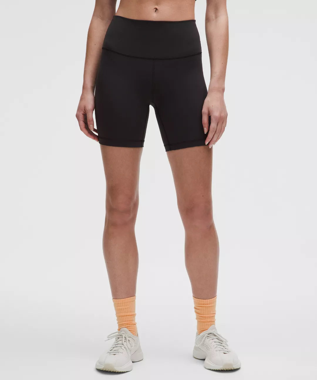 Person wearing black athletic shorts on a white background