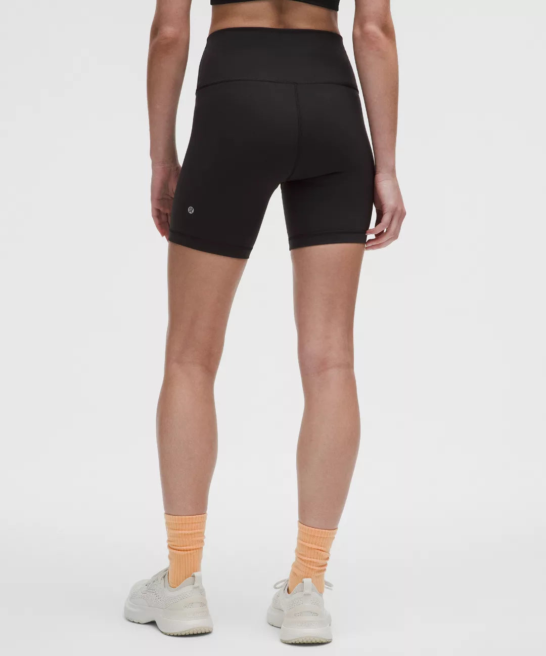 Person wearing black athletic shorts on a white background