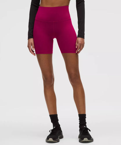 Person wearing bright pink athletic shorts on a white background